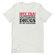 Ash color “Hey TSA! I’m Definitely Not Carrying Drugs in My Cavities” prank T-shirt with bold red and black text.