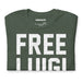 Folded Heather Forest FREE LUIGI T-shirt showcasing bold, distressed lettering and soft fabric texture.