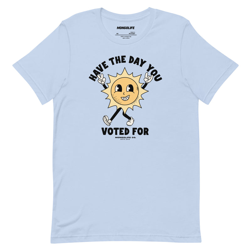 Baby blue t-shirt with a vintage-style sun illustration and the text "Have The Day You Voted For" in bold, retro-inspired font.