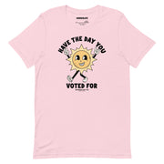 Soft pink t-shirt featuring a cheerful yet sarcastic sun cartoon with the phrase "Have The Day You Voted For."
