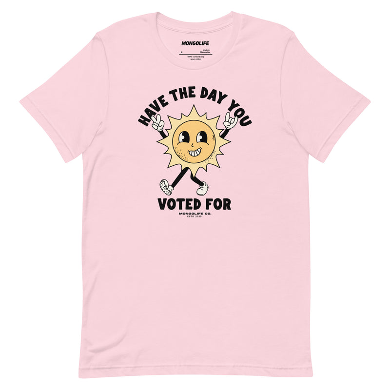 Soft pink t-shirt featuring a cheerful yet sarcastic sun cartoon with the phrase "Have The Day You Voted For."