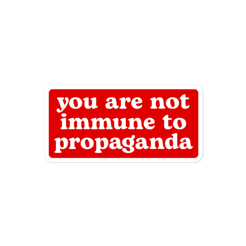 "You Are Not Immune to Propaganda" sticker in striking white text on a red background.