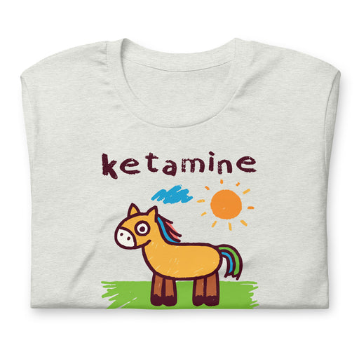 Folded ash color T-shirt with a cartoon horse drawing and 'ketamine' written in crayon font.