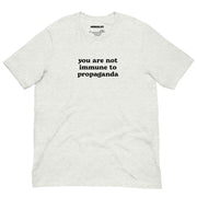Light ash grey t-shirt with the phrase "You Are Not Immune to Propaganda" in bold black text.