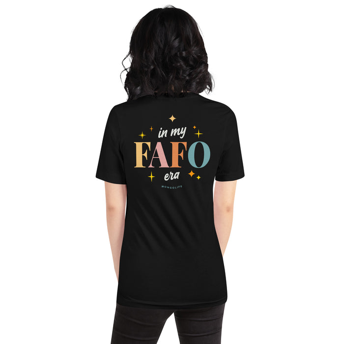 Female model showcasing the back of the black T-shirt with a large, colorful "In My FAFO Era" print surrounded by sparkling stars.