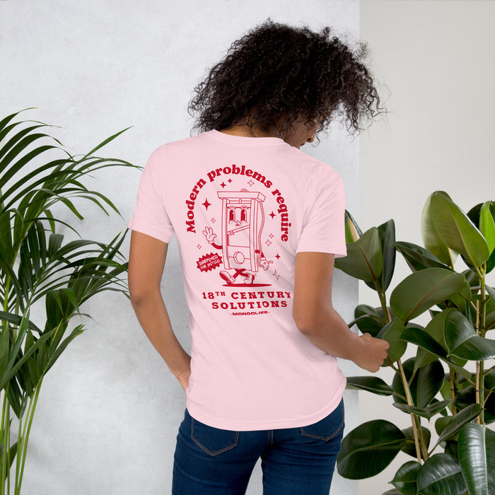 A woman modeling the full satirical back design of the soft pink T-shirt featuring the guillotine cartoon and commentary on politics.