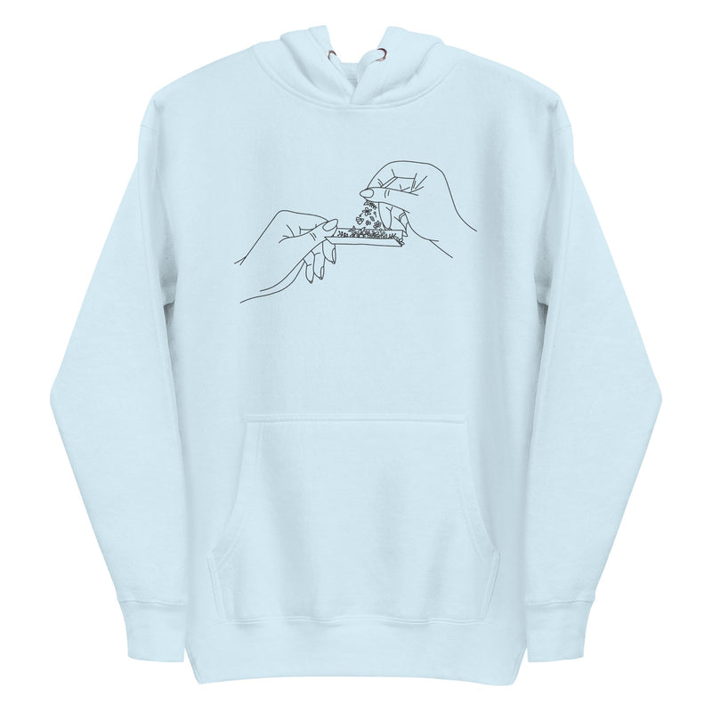 Black and white line art of two hands rolling a joint with flowers, meticulously embroidered on the front chest of a soft, sustainable baby blue hoodie.