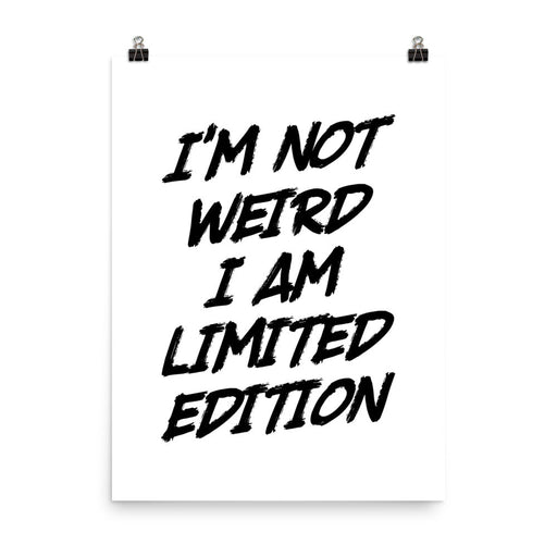 Poster print with bold black brush-style text reading “I’m not weird, I am limited edition” on a white background with metal clips.