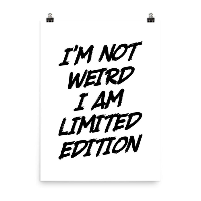 Poster print with bold black brush-style text reading “I’m not weird, I am limited edition” on a white background with metal clips.