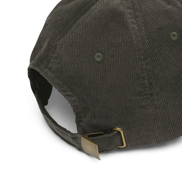 Back strap of Olive Leaf - Vintage Corduroy Caps laid flat on a white background, showcasing the embroidered green cannabis leaf and gold-colored metal buckle.