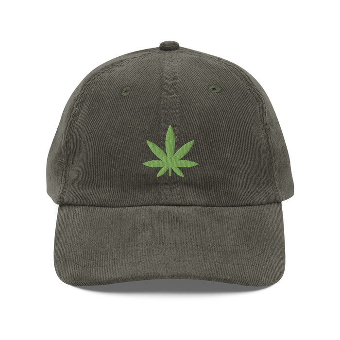 Olive Leaf - Vintage Corduroy Caps laid flat on a white background, showcasing the embroidered green cannabis leaf and gold-colored metal buckle.