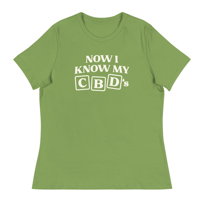 Flat lay of the green Now I Know My CBDs Women's Relaxed T-Shirt on a white background, featuring a colorful design that puts a CBD-inspired twist on the classic alphabet song.
