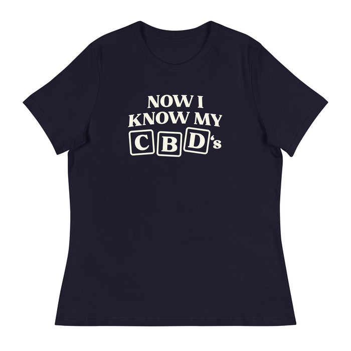 Flat lay of the navy Now I Know My CBDs Women's Relaxed T-Shirt on a white background, featuring a colorful design that puts a CBD-inspired twist on the classic alphabet song.