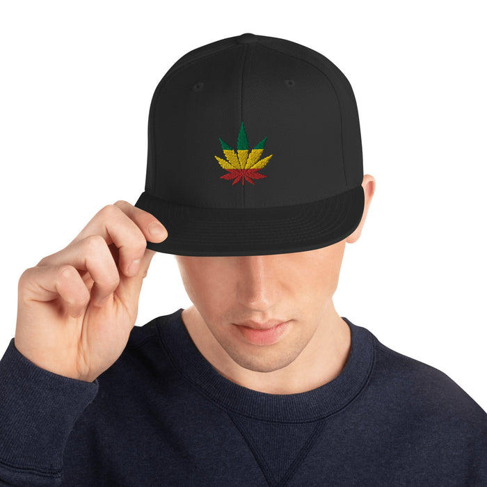 man wearing "Rasta Striped Leaf" Snapback Hat with embroidered cannabis leaf in green, yellow, and red, on a structured, adjustable cap.